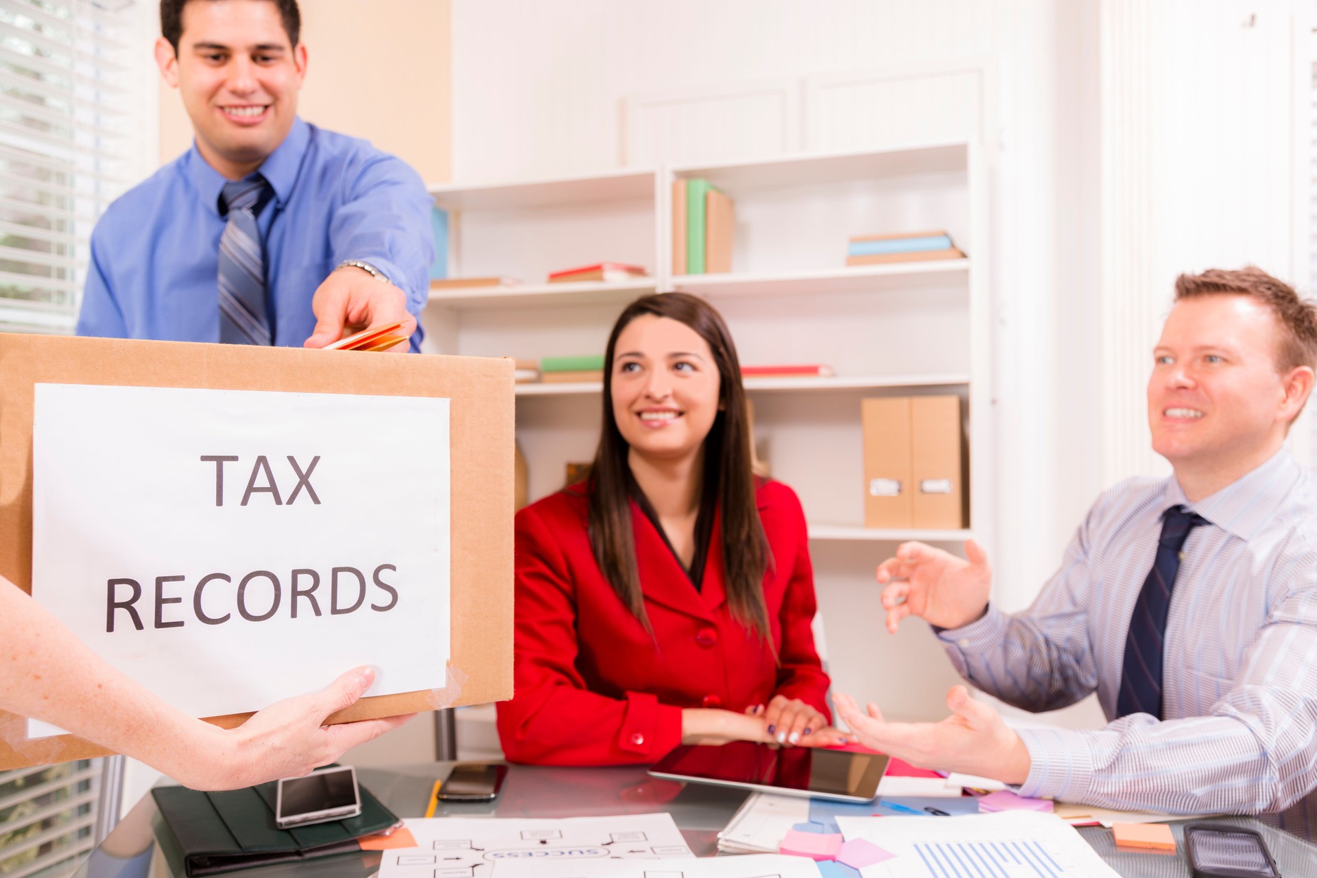 Accountants collaborate on income tax returns. Box foreground.